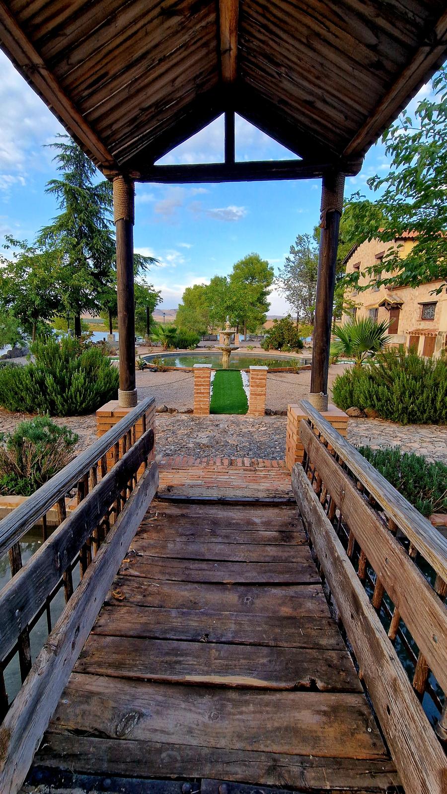 Pasarela de madera bajo la pérgola del jardín
