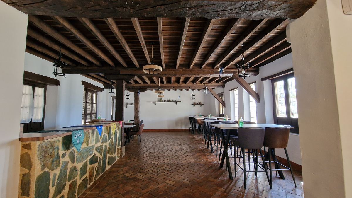 Salón con barra de piedra y techo de vigas de madera