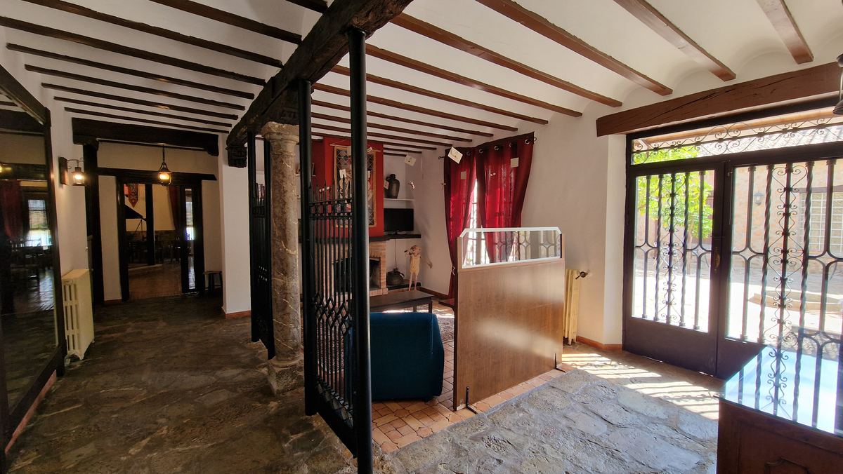Sala común con vigas de madera y salida al patio
