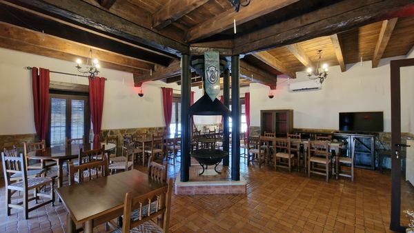 Comedor con mesas para grupos y chimenea central