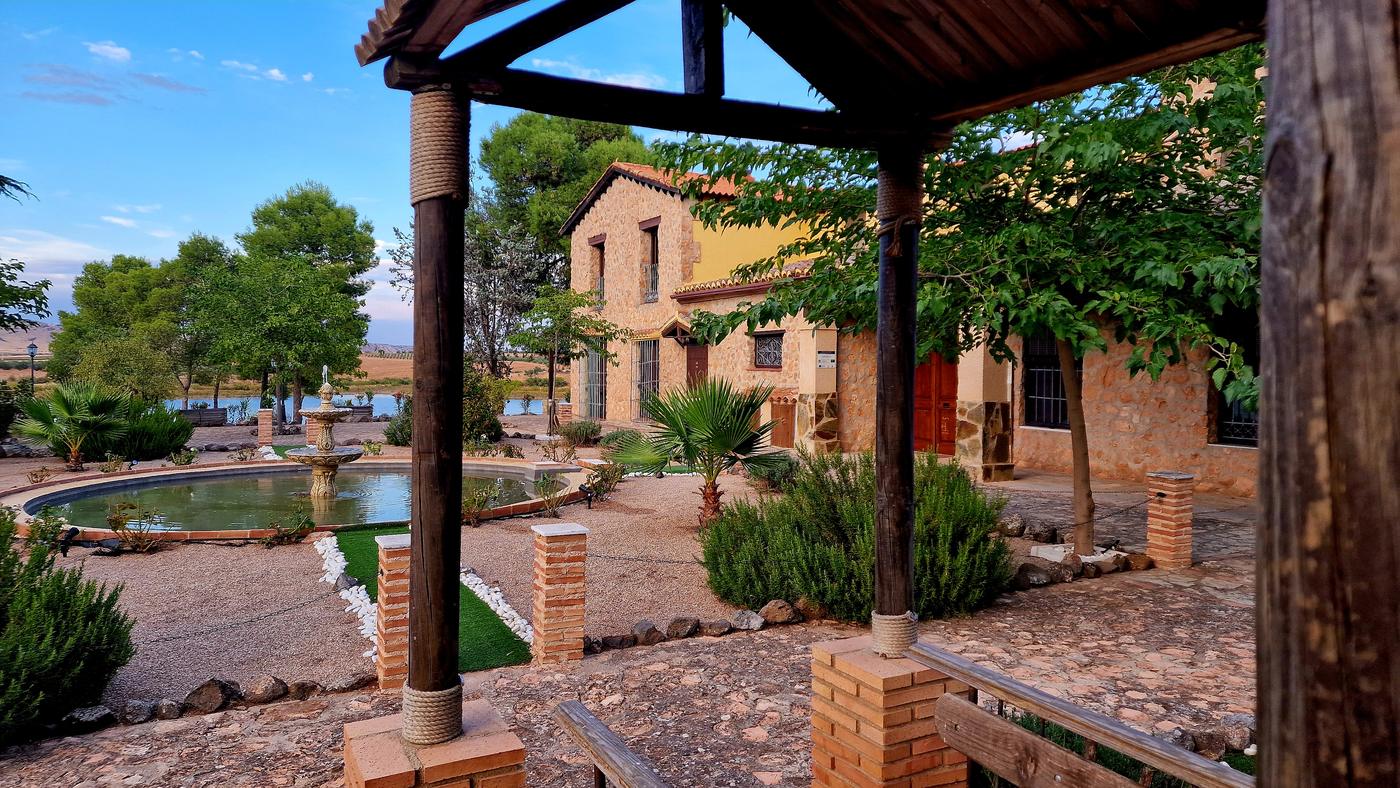 Pérgola y estanque del jardín con el embalse al fondo